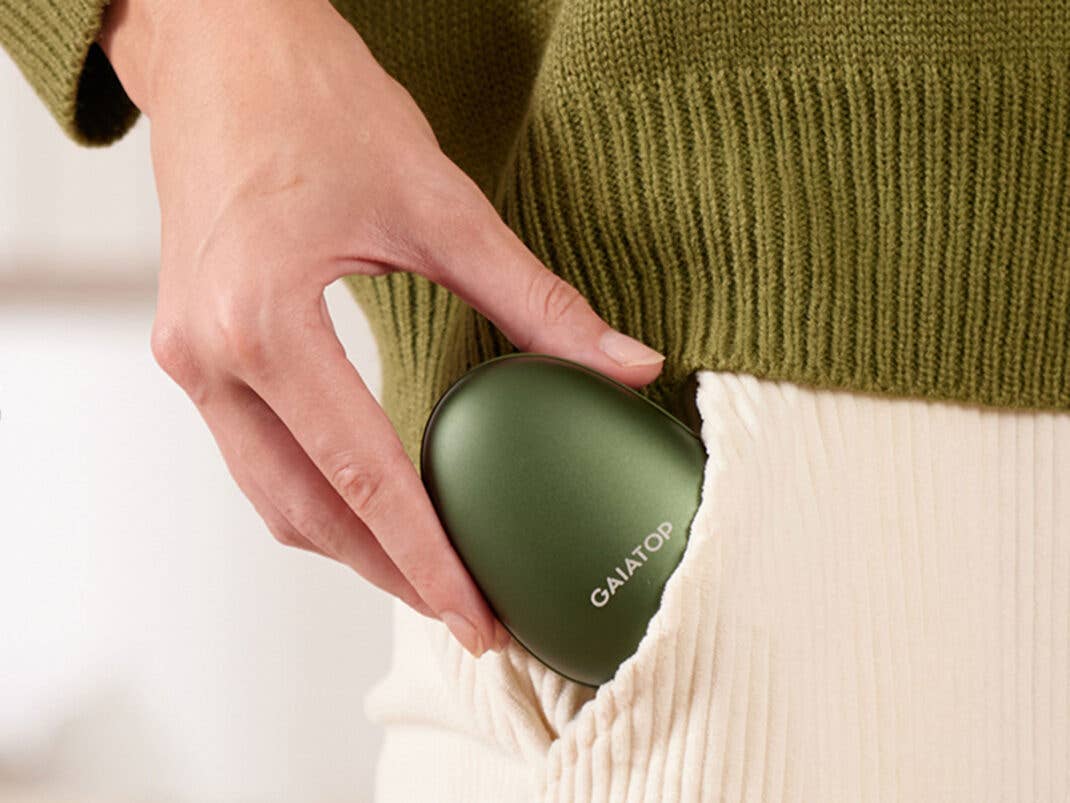 Eine Person steckt einen Handwärmer in Form einer Avocado in ihre Hosentasche