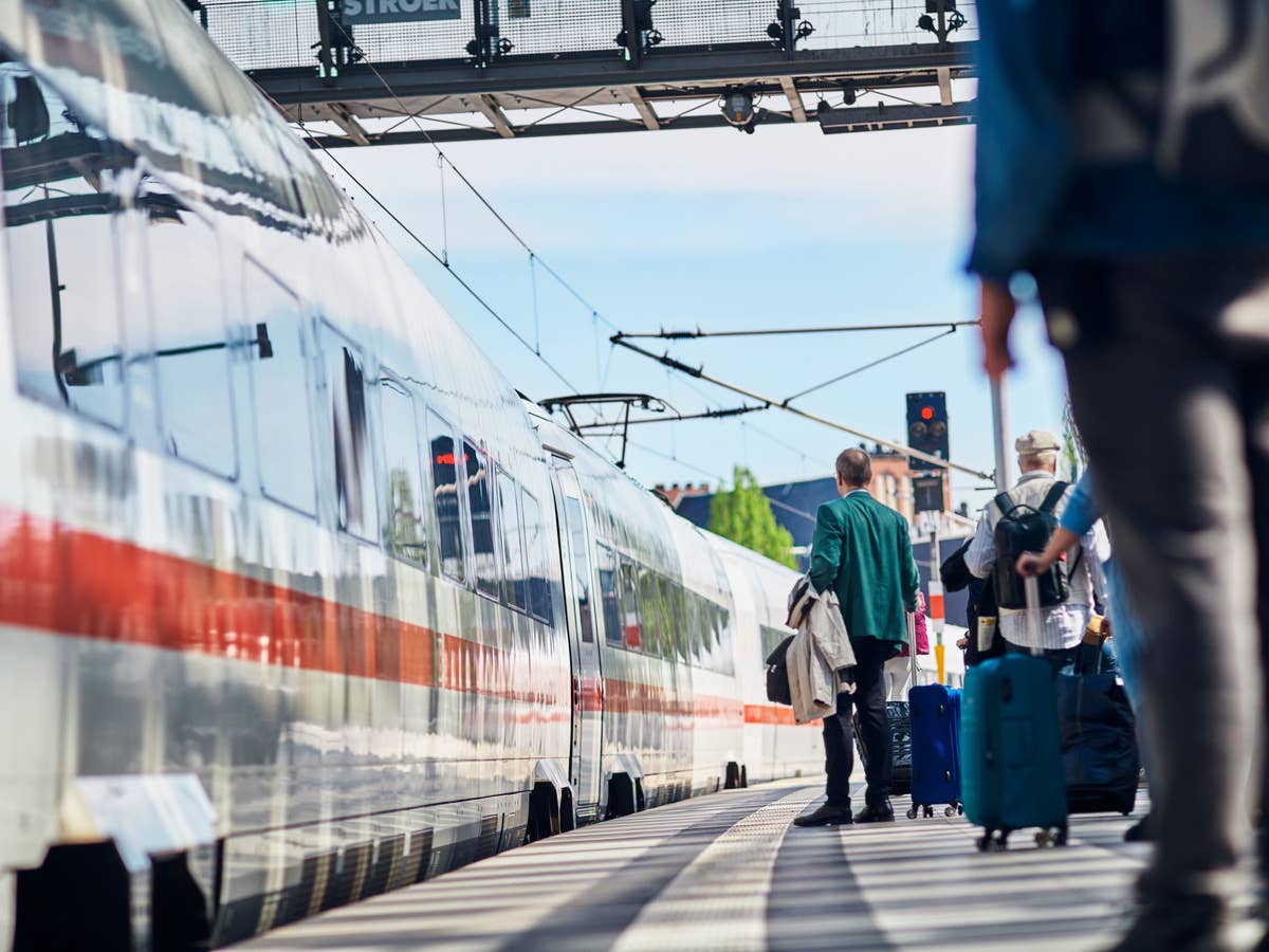 Reisende und einfahrender ICE im Berliner Hauptbahnhof