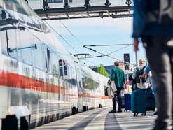 Reisende und einfahrender ICE im Berliner Hauptbahnhof