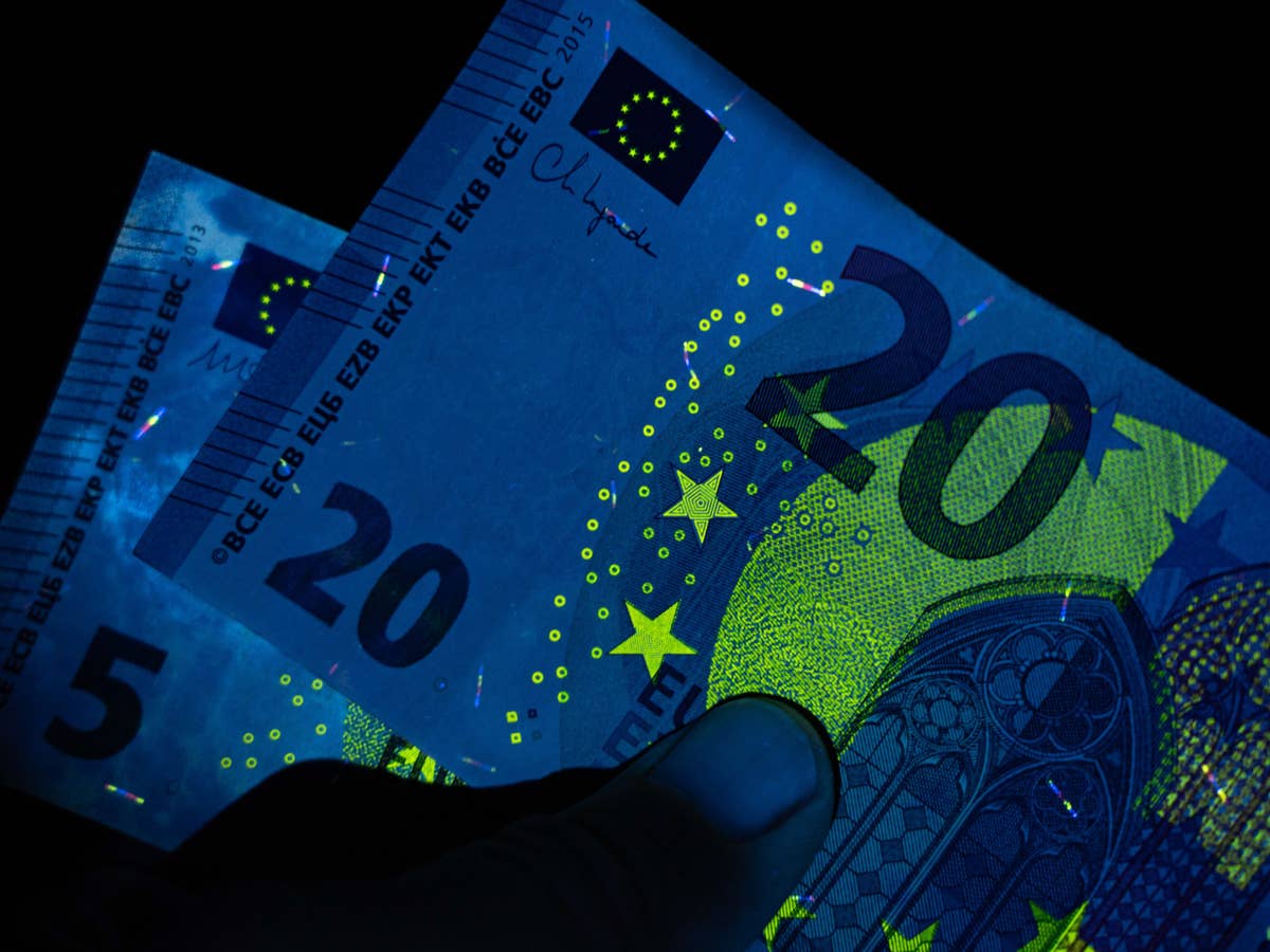 Bargeld: Eine 5- und eine 20-Euro-Note unter Schwarzlicht