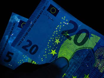 Bargeld: Eine 5- und eine 20-Euro-Note unter Schwarzlicht