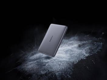 Baseus PicoGo Powerbank, Powerbank an Smartphone vor schwarzem Hintergrund