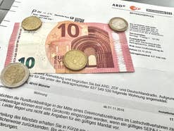 Schreiben von Beitragsservice ARD ZDF Deutschlandradio mit Münzen und 10-Euro-Schein.
