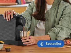Eine Person, die einen Kaffee aus einer Kaffeemaschine bezieht
