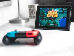 Nintendo Switch Kontroller vor Switch Konsole mit Animal Crossing als Startbildschirm