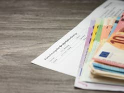 Gehaltsabrechnung mit Euroscheinen davor