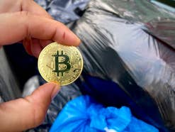 Bitcoin mit Müllsäcken im Hintergrund