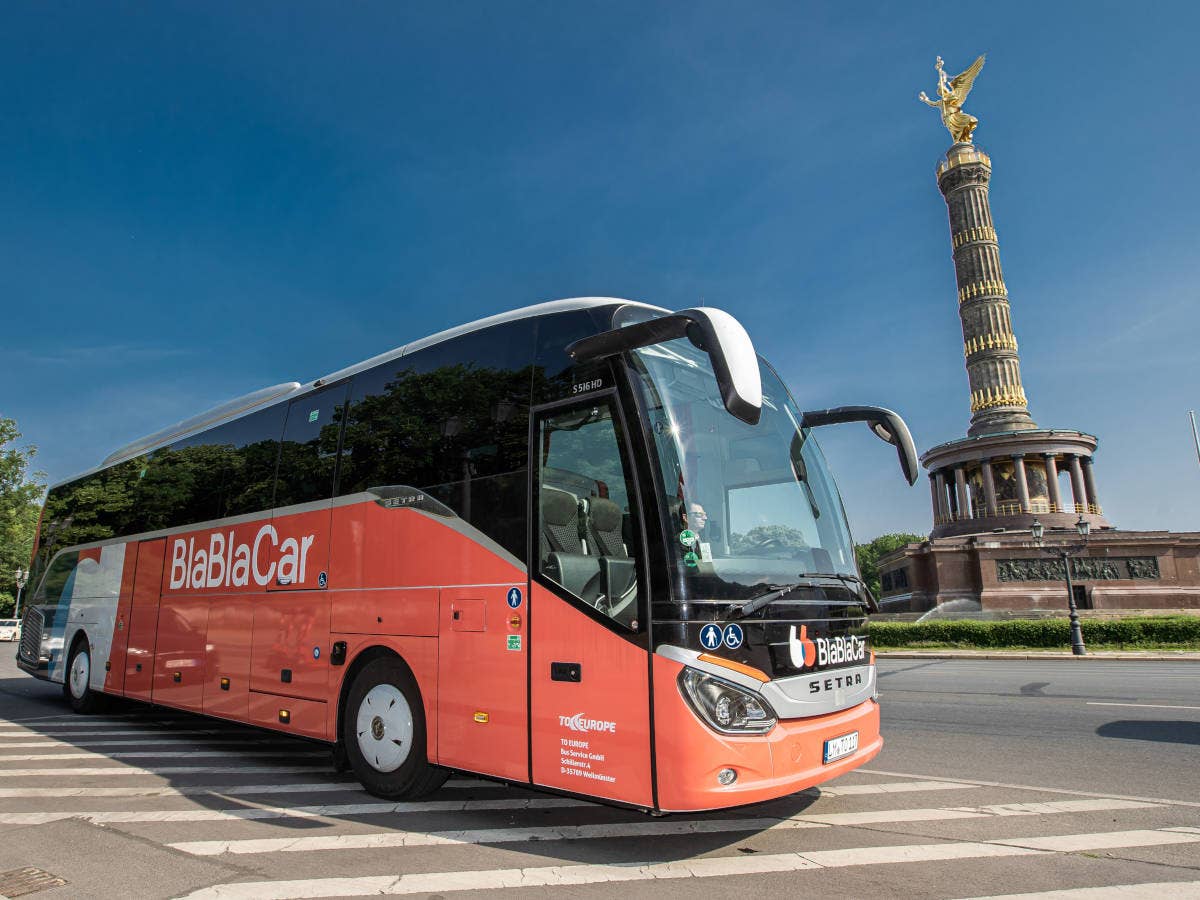 BlaBlaCar Bus in Berlin vor Siegessäule stehend.