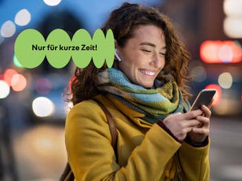 Junge Frau lächelt in ihr Smartphone