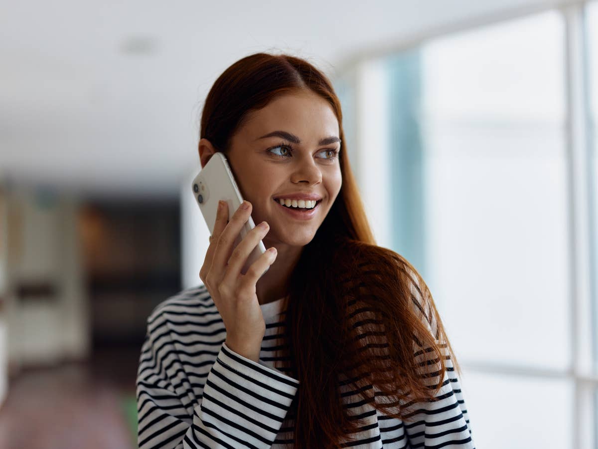 Frau mit Smartphone am Ohr.