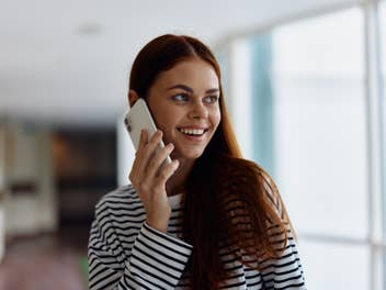 Frau mit Smartphone am Ohr.