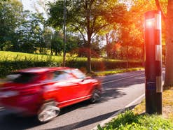 Blitzer blitzt ein Auto, das zu schnell fährt.
