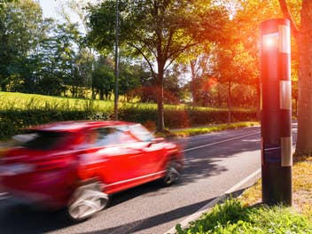 Blitzer blitzt ein Auto, das zu schnell fährt.