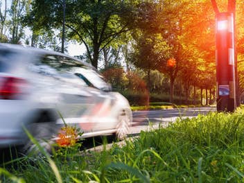 Ein Auto fährt auf einen Blitzer zu, der ausgelöst wird