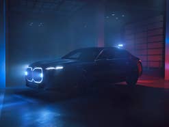 BMW i7 Protection steht in einer dunklen Halle mit eingeschalteten Signallichtern.