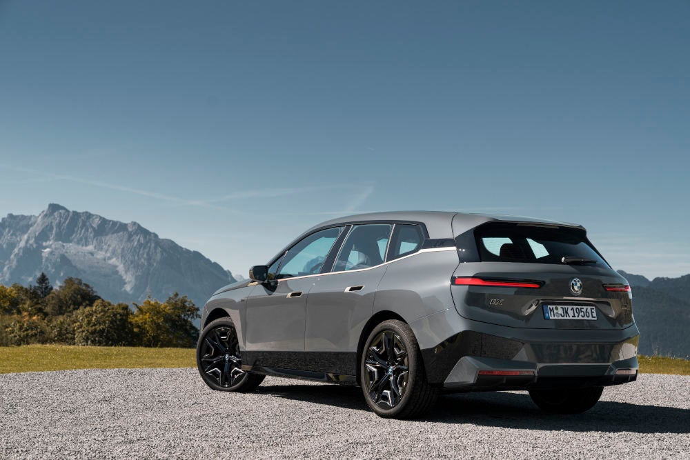 BMW iX M60 steht vor einem Bergpanorama.