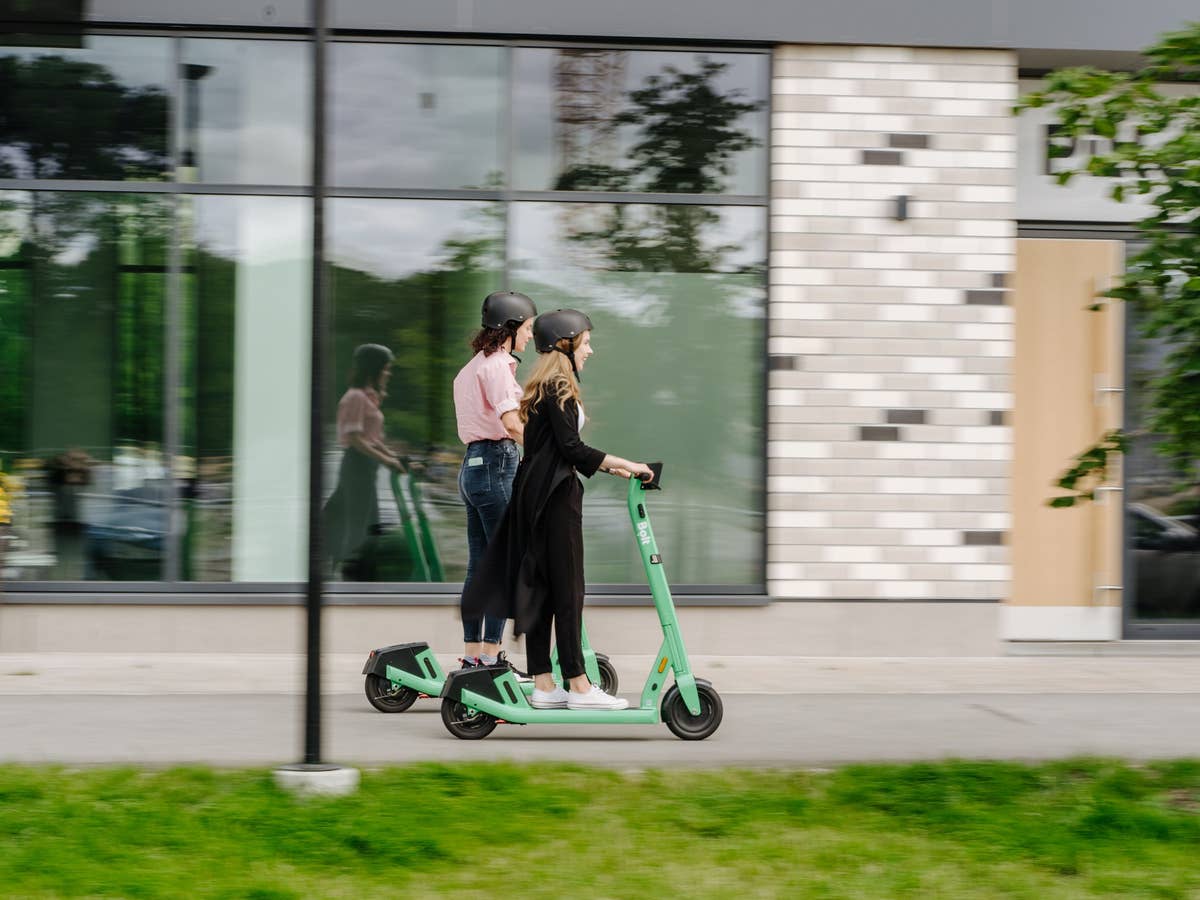 Zwei Frauen fahren auf E-Scootern von Bolt.