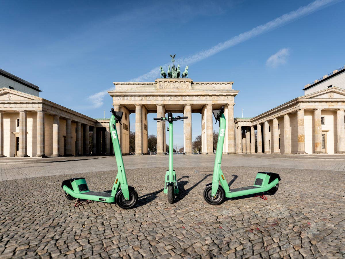 Drei E-Scooter von Bolt stehen in Berlin vor dem Brandenburger Tor.