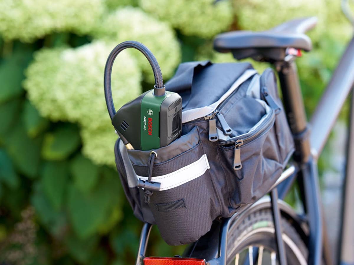 Eine elektrische Luftpumpe von Bosch steckt in einer Packtasche hinten auf einem Fahhrad