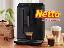Bosch-Kaffeevollautomat auf einem Tisch, daneben Kaffeegetränke und das Netto-Logo