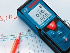Bosch Professional Laser-Entfernungsmesser GLM40 liegt auf einem Zettel mit Bauzeichnungen