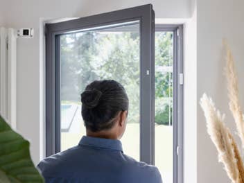 Smarte Türkontakte von Bosch an einer Tür angebracht, die ein Mann öffnet