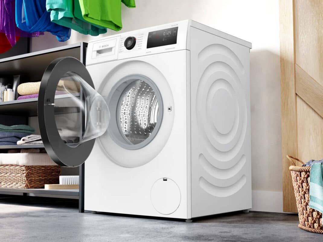Eine Bosch-Waschmaschine steht mit offenem Bullauge im Waschraum