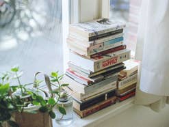 Bücher gestapelt auf einer Fensterbank.