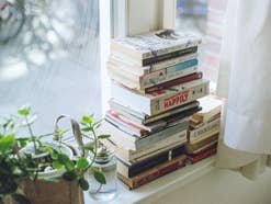 Bücher Apps Bücher gestapelt auf einer Fensterbank.