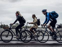 Drei Personen unterwegs auf dem Fahrrad auf einer Straße