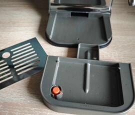 Das Gitter lässt sich abnehmen und die Auffangschale darunter herausnehmen und so leicht säubern. Der Schwimmer (orange) zeigt zudem an, wenn sie voll ist. Abtropfschale der Krups Coffee Crush auseinander genommen