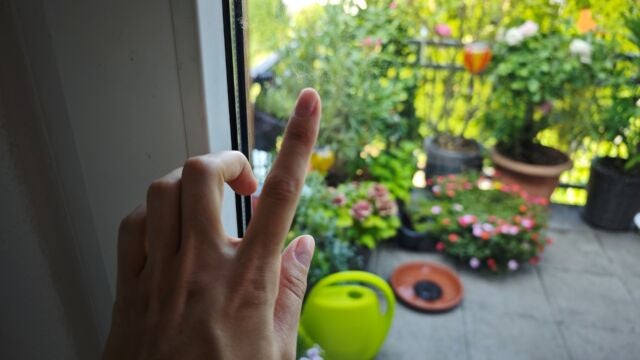 Der WINBOT tut sich vor allem an Rändern schwer. Finger zeigt auf schmutzige Stelle am Fenster