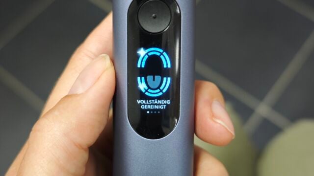 Direkt nach dem Putzen zeigt das Display an, ob du alle Bereiche im Mund ausreichend geputzt hast. Hand hält Philips Sonicare Next-Generation DiamondClean 9900 Prestige