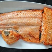 Der Lachs musste aufgrund der kleineren Behälter zerlegt werden. Eine zerschnittene Portion knusprig gebackenem Lachs