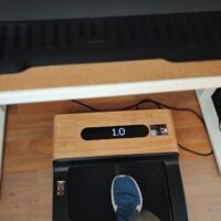 Das WoodPad Pro eignet sich fürs arbeiten am höhenverstellbaren Schreibtisch im Homeoffice. WoodPad Pro von oben über einem Schreibtisch aufgenommen und der Fuß einer Person steht drauf