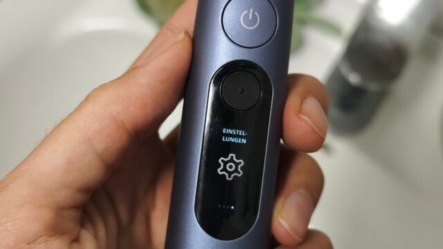 Einstellungen Hand hält Philips Sonicare Next-Generation DiamondClean 9900 Prestige über dem Waschbecken