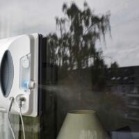 Der HAVA U01 sprüht nur aus einer Düse pro Seite und das auch nur schräg nach unten. der HAVA U01 Fensterputzroboter an einer Fensterscheibe sprüht in Fahrtrichtung nach rechts