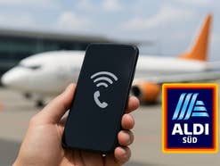 Ein Smartphone und ein Aldi-Logo, im Hintergrund ein Flugzeug