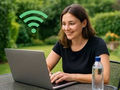 Eine Frau sitzt im Garten an ihrem Laptop