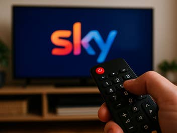 Ein TV mit einem Sky-Logo, im Vordergrund eine Fernbedienung