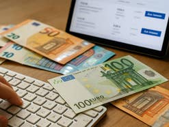 Eine Tastatur mit Geldscheinen und einen Bildschirm