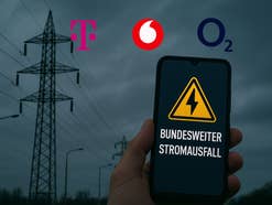 Ein Strommast, ein Handy, ausgeschaltete Straßenlaternen in der Dunkelheit und die Logos der Mobilfunknetzbetreiber