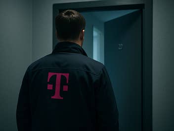 Ein Vertreter mit einer Telekom-Jacke steht vor einer geöffneten Wohnungstür
