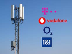 Ein Mobilfunksendemast mit den Logos der vier deutschen Netzbetreiber