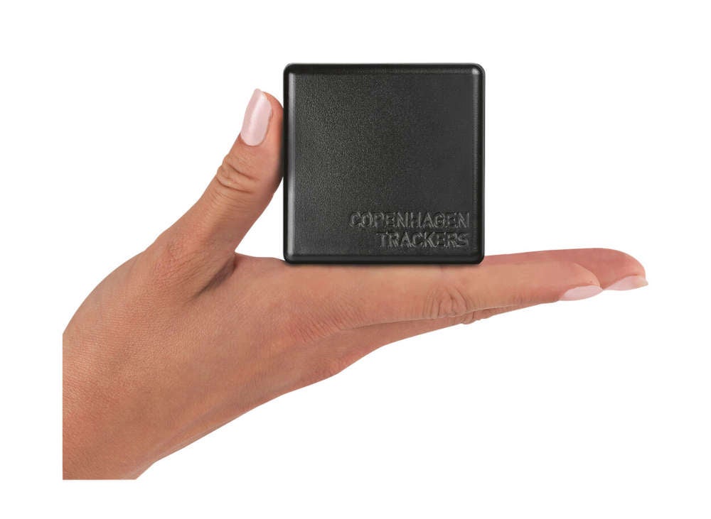 Cobblestone GPS-Tracker in Schwarz steht auf einer Hand einer Frau.