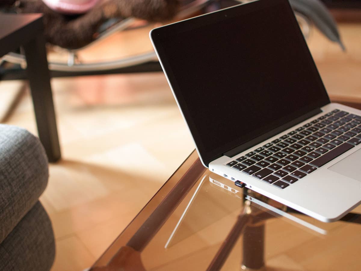 Ein Laptop steht auf einem Glastisch im Wohnzimmer