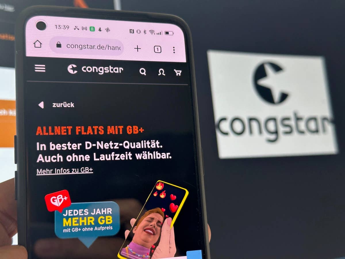 Smartphone mit Congstar-Homepage auf Bildschirm vor Congstar-Logo im Hintergrund.