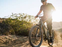 Man fährt mit einem Crossover-E-Bike im Gelände.