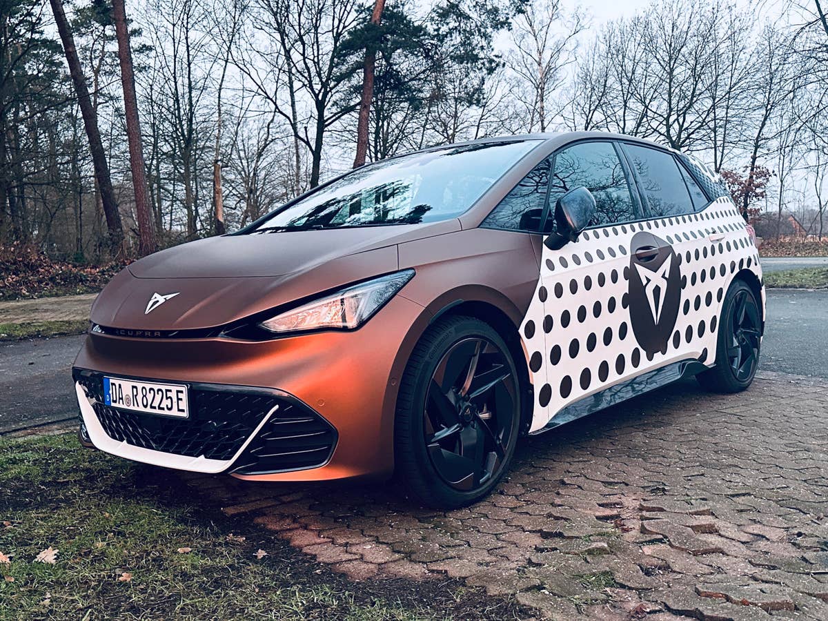 Cupra Born steht im Licht der aufgehenden Sonne auf einem Parkplatz.