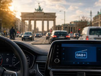 Ein Autoradio mit DAB+, im Hintergrund das Brandenburger Tor